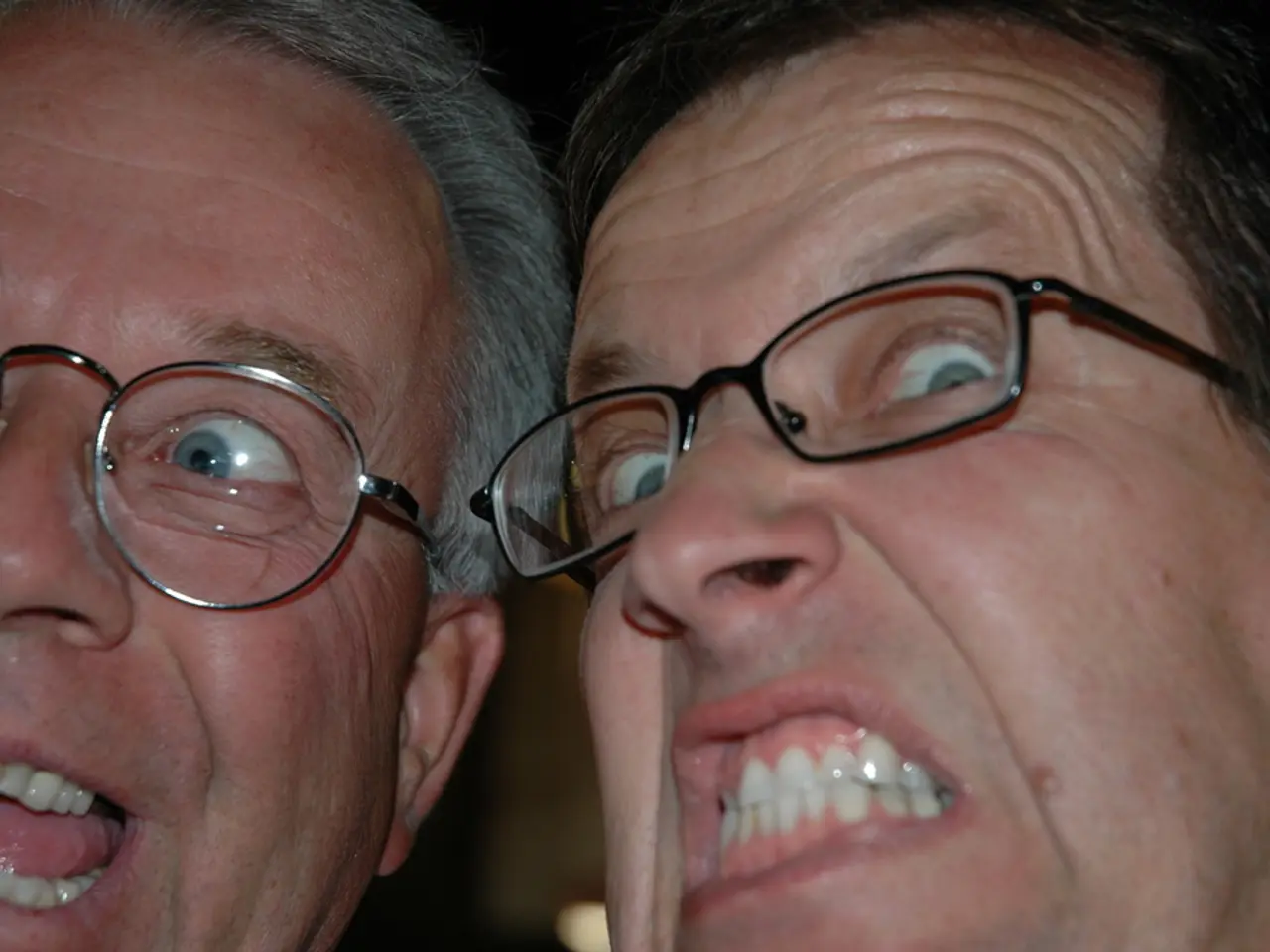 In the picture we can see two men are facing giving some expressions showing their teeth.