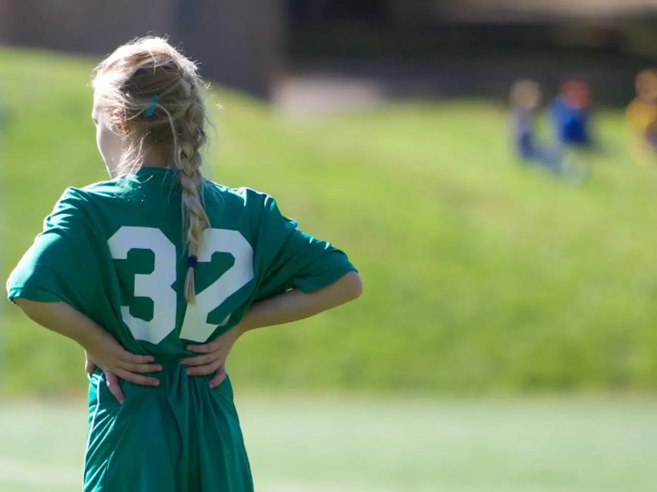 In the picture I can see a kid wearing green T-shirt is standing on a greenery ground in the left...