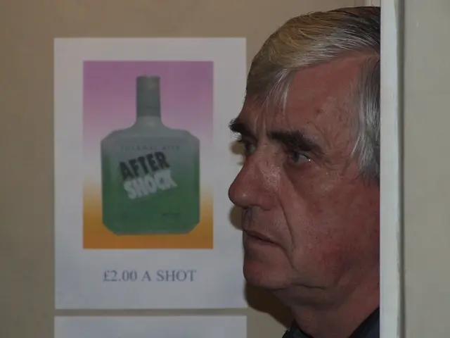 In this image we can see a person's face and we can also see an after shock bottle on the paper...