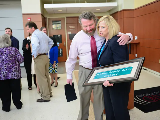 In this image there are group of personś standing, there is a person holding an object, there is a...