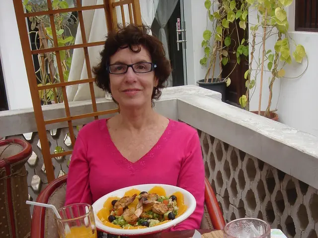 Here a woman is sitting on the chair, she wore pink color dress, spectacles. These are the food...