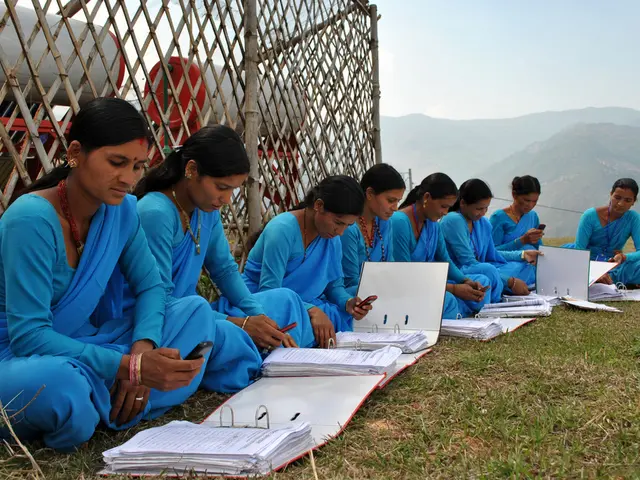In this image we can see eight ladies are sitting on floor and they are wearing blue color dress...