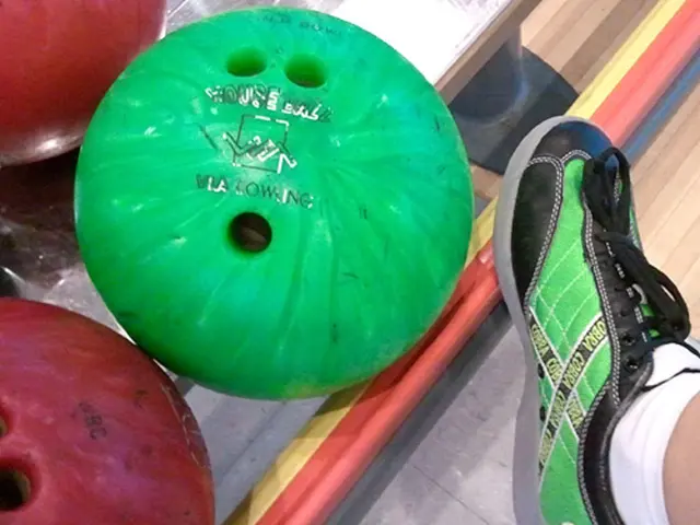 The picture consists of bowling balls. On the right there is a person's leg. At the bottom it is...